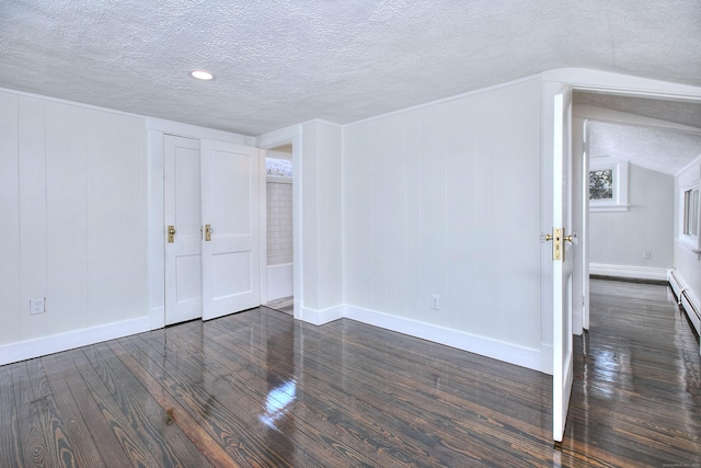 unfurnished room featuring dark hardwood / wood-style floors, vaulted ceiling, and a textured ceiling