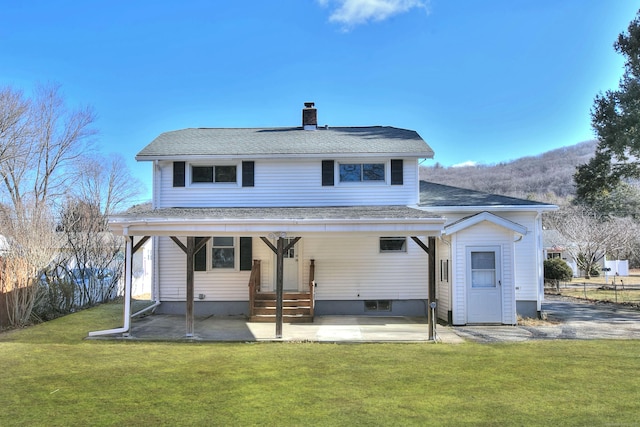 rear view of house with a patio area and a lawn