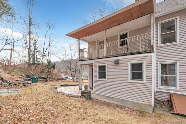 view of side of property featuring a patio and a balcony