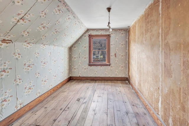 bonus room with hardwood / wood-style flooring and vaulted ceiling