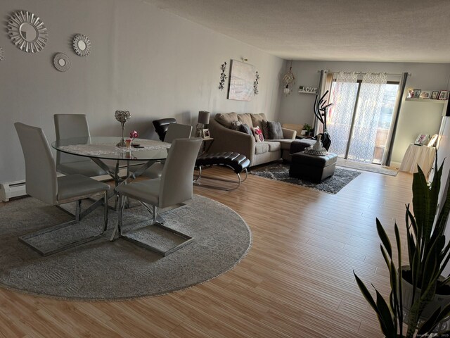 dining room with a baseboard radiator and light wood-type flooring