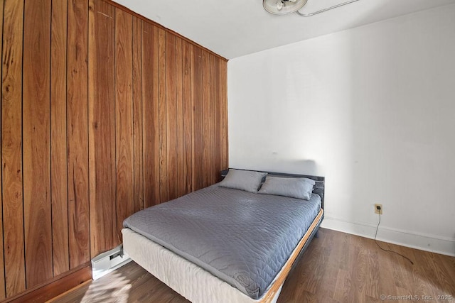 bedroom featuring baseboard heating and dark hardwood / wood-style floors