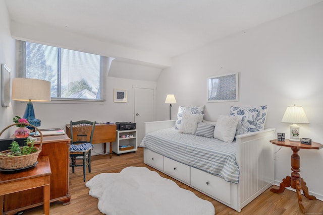 bedroom featuring hardwood / wood-style flooring and lofted ceiling