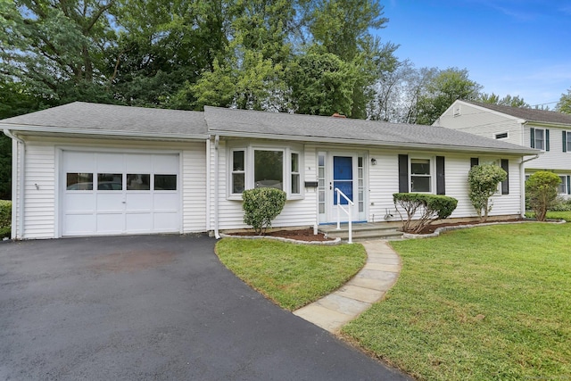 ranch-style home with a garage and a front lawn