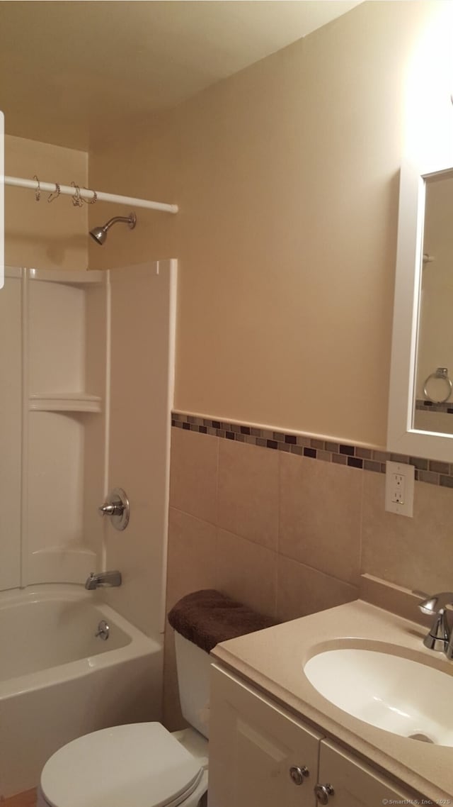 full bathroom featuring tile walls, vanity, shower / tub combination, and toilet