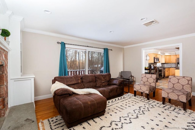 living room featuring sink, crown molding, and light hardwood / wood-style flooring