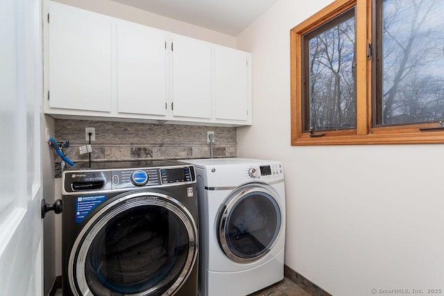 clothes washing area with cabinets and separate washer and dryer