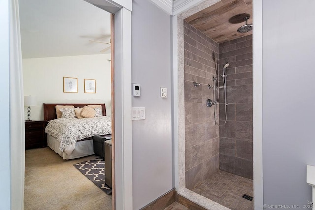 bathroom with ceiling fan, vaulted ceiling, and tiled shower