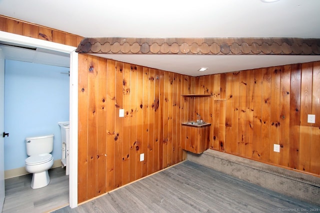 spare room featuring wood-type flooring and wooden walls