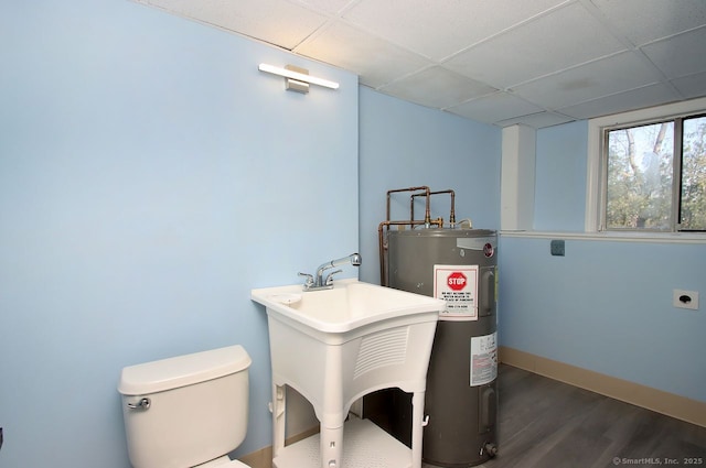 bathroom with sink, hardwood / wood-style flooring, a paneled ceiling, water heater, and toilet