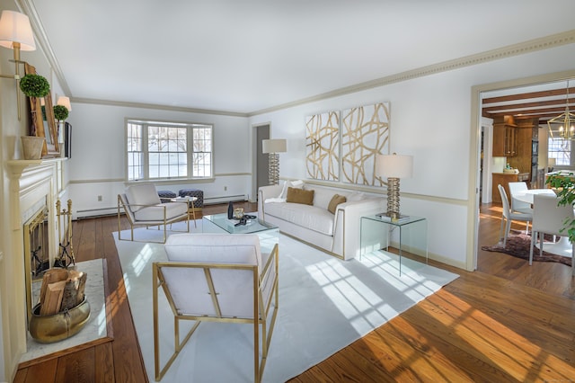 living room featuring a notable chandelier, ornamental molding, hardwood / wood-style floors, and a baseboard heating unit