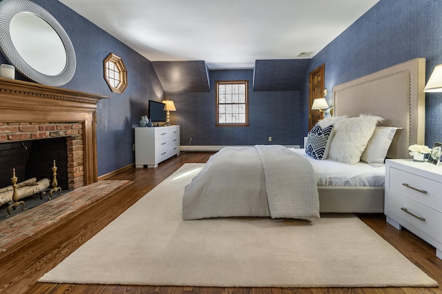 bedroom featuring dark wood-type flooring and a fireplace