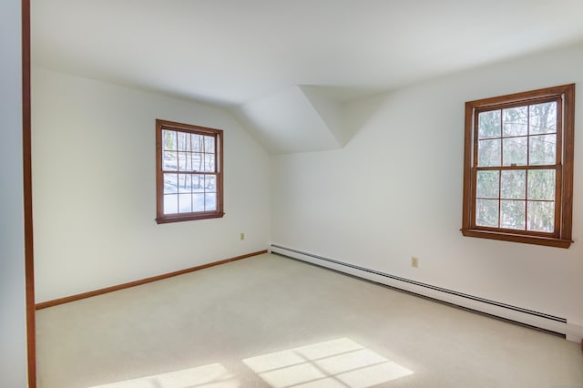 additional living space with light carpet, a baseboard radiator, and vaulted ceiling