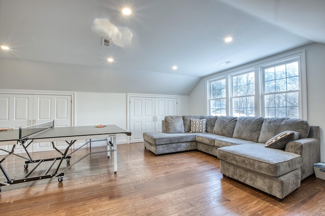 living area with recessed lighting, visible vents, vaulted ceiling, and wood finished floors