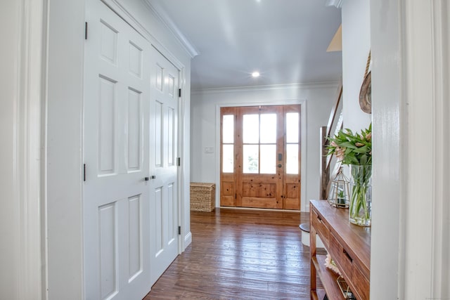 foyer with dark wood-style flooring and crown molding