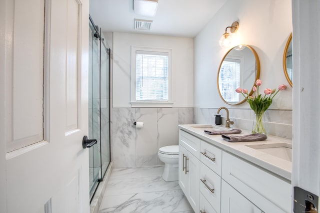 bathroom with marble finish floor, double vanity, toilet, a sink, and a shower stall