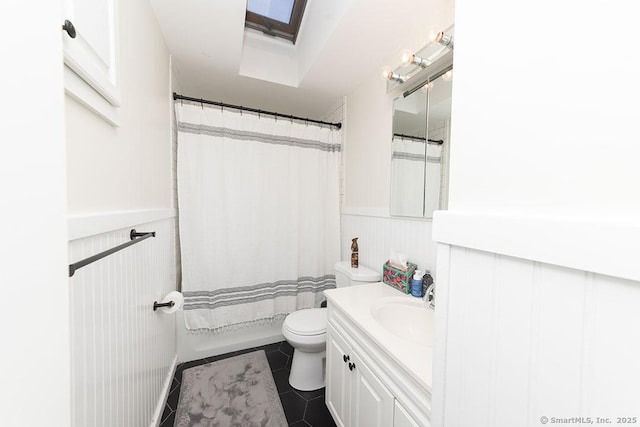 bathroom with vanity, a skylight, tile patterned floors, and toilet