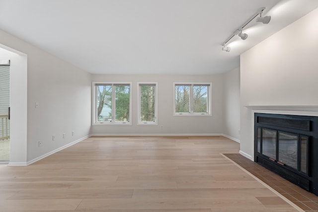 80 Seaview Ter Unit 12, Guilford, CT 06437 - unfurnished living room with a fireplace with flush hearth, light wood-style flooring, track lighting, and baseboards