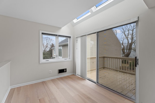 unfurnished room featuring light hardwood / wood-style flooring and lofted ceiling with skylight