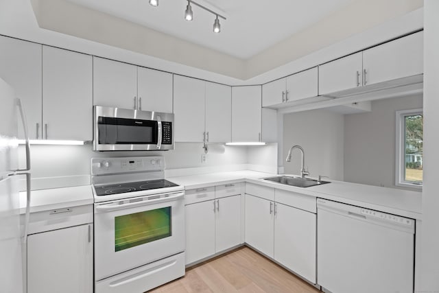 kitchen featuring white cabinetry, sink, light hardwood / wood-style floors, track lighting, and white appliances