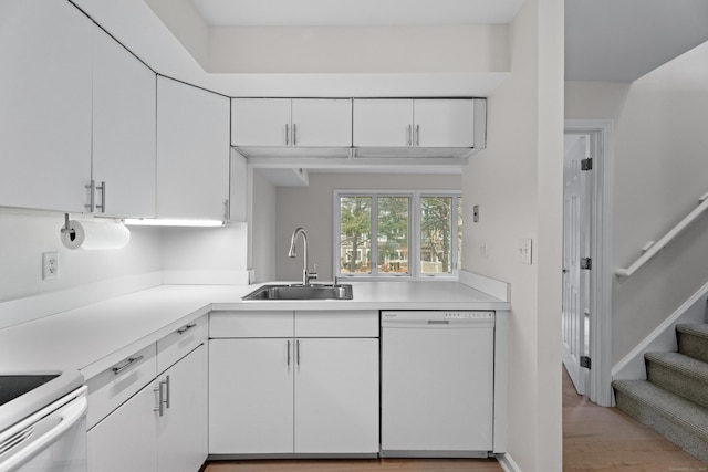 kitchen featuring dishwasher, sink, white cabinets, and electric stove