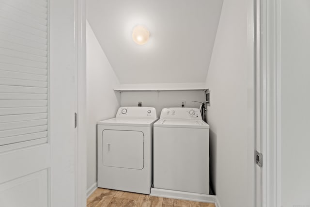 laundry area with washer and dryer and light hardwood / wood-style flooring