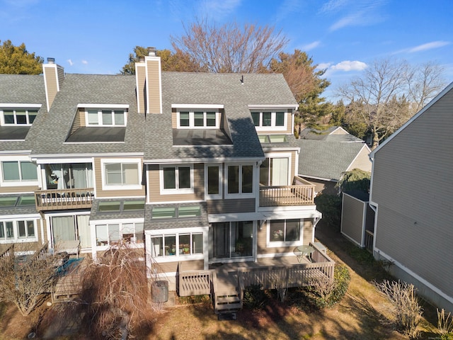 rear view of property featuring a wooden deck and a balcony