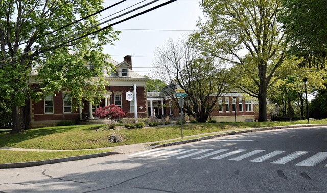 34 Lyme St, Old Lyme, CT 06371 - greek revival inspired property featuring brick siding, a front yard, and a chimney