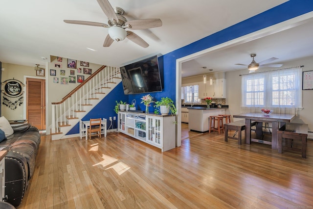 living room featuring sink, ceiling fan, and light hardwood / wood-style flooring