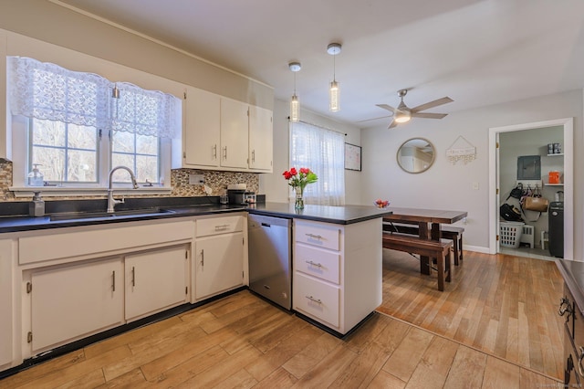 kitchen featuring sink, dishwasher, tasteful backsplash, white cabinets, and light wood-type flooring