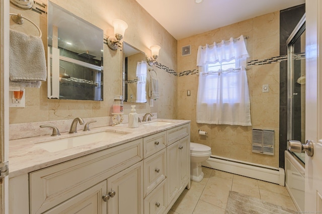 bathroom featuring tile walls, a baseboard heating unit, tile patterned flooring, vanity, and toilet