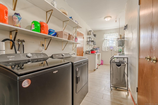 laundry area with separate washer and dryer and light tile patterned floors