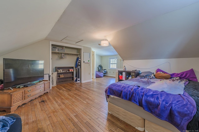 bedroom with lofted ceiling, hardwood / wood-style floors, and a closet