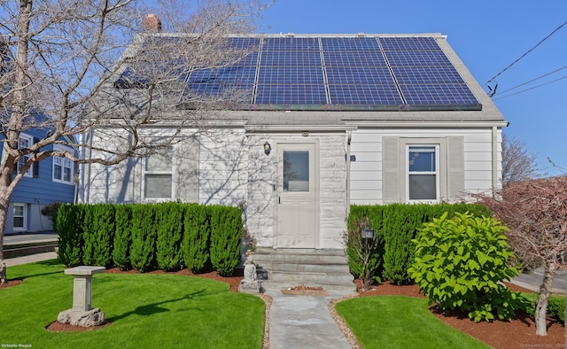 view of front facade featuring a front lawn and solar panels