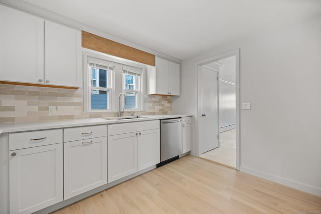 kitchen with sink, stainless steel dishwasher, white cabinets, and a baseboard heating unit