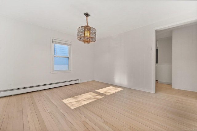 spare room with a baseboard radiator and light wood-type flooring