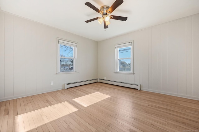 spare room with ceiling fan, plenty of natural light, and light wood-type flooring