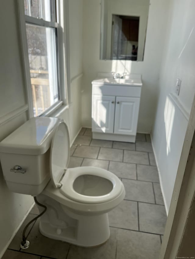 bathroom with tile patterned flooring, vanity, and toilet