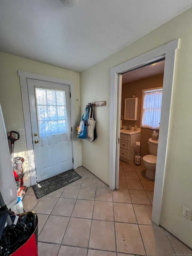 doorway to outside with light tile patterned floors