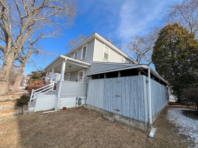 view of side of home featuring covered porch