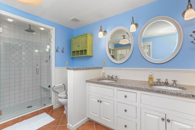 bathroom featuring vanity, a shower with shower door, tile patterned floors, and toilet