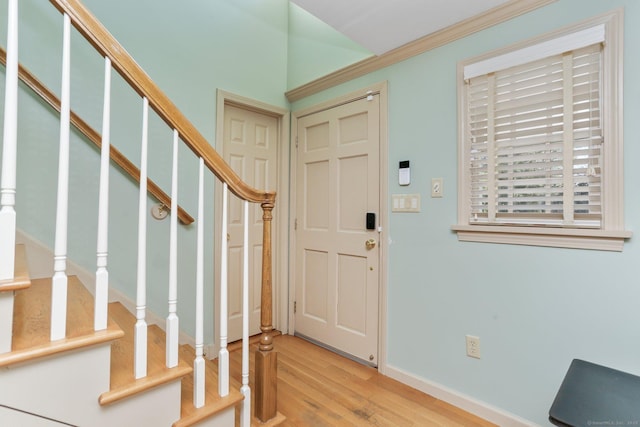 entrance foyer with ornamental molding and light wood-type flooring