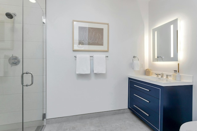 bathroom with a shower with door, vanity, and tile patterned floors