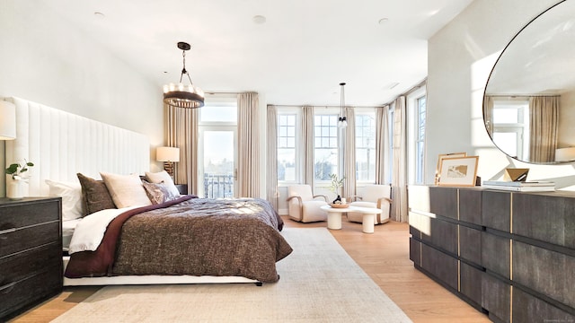 bedroom featuring a chandelier and light wood-type flooring