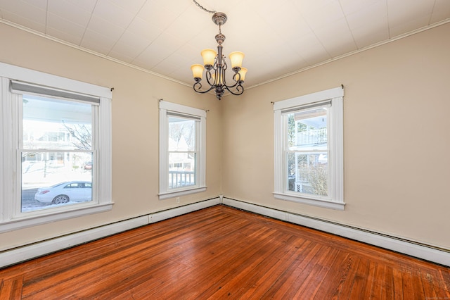 spare room featuring hardwood / wood-style flooring, crown molding, an inviting chandelier, and a baseboard radiator