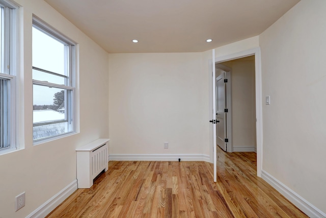 702 King St, Stratford, CT 06614 - spare room with light wood finished floors, baseboards, recessed lighting, and radiator