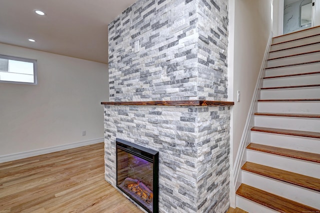 702 King St, Stratford, CT 06614 - stairway with a stone fireplace, wood finished floors, recessed lighting, and baseboards