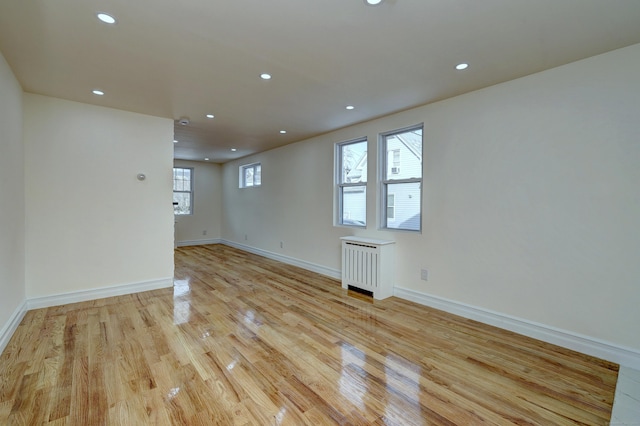 702 King St, Stratford, CT 06614 - empty room with radiator, light wood-style floors, recessed lighting, and baseboards