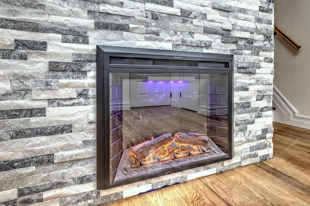 702 King St, Stratford, CT 06614 - detailed view of wood finished floors, a wainscoted wall, and a stone fireplace