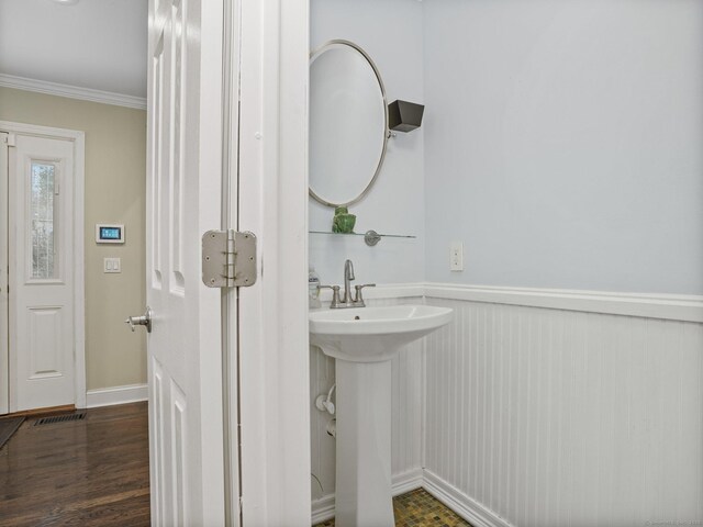 bathroom with crown molding and hardwood / wood-style flooring